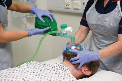 Two people ventilating a patient using a Mapleson C system.